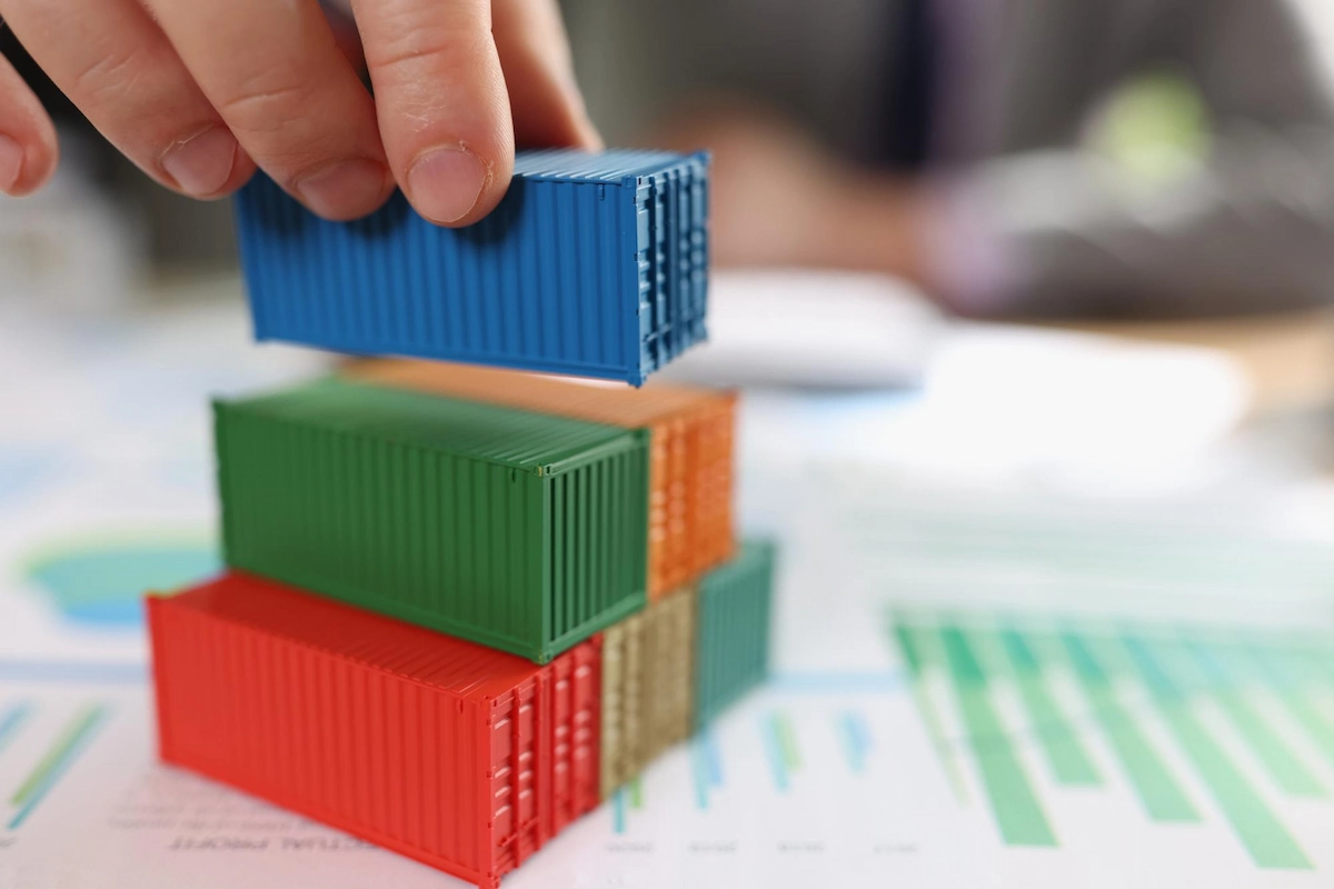 A stack of cargo containers on top of financial report documents