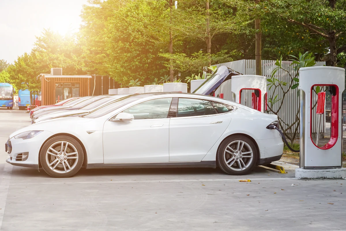 An electric car is charging at a public charging station (PEVCS)